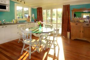 a kitchen with a table and chairs in a kitchen at Fantail Cottage in Oamaru