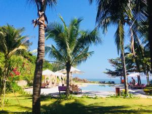 a resort with palm trees and a swimming pool at Casa Marina Resort in Quy Nhon