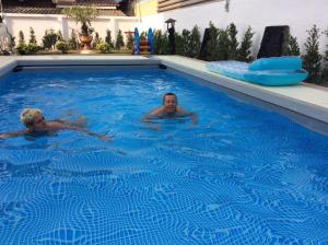 twee mannen zwemmen in een zwembad bij avalon residence2 in Savannakhet