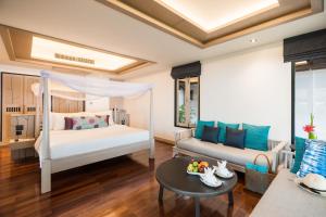 ein Schlafzimmer mit einem Bett und einem Sofa in der Unterkunft Barali Beach Resort & Spa in Ko Chang