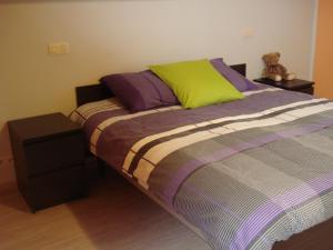 una camera da letto con un letto con cuscini viola e verdi di Auro'ra a Zedelgem