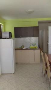 cocina con nevera blanca y mesa en Apartments Diva, en Novalja