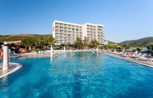 a hotel swimming pool with people in the water at Tusan Beach Resort - All Inclusive in Kuşadası