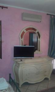 a dressing table with a mirror on a pink wall at B&B Villa Giovanni in Casal Palocco