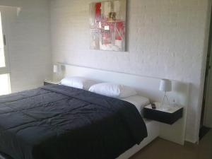 um quarto com uma cama e uma fotografia na parede em Palmeras Beach Hotel em Punta del Este