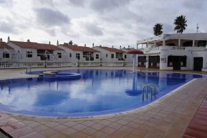 una gran piscina frente a un edificio en Apartamento el Descanso, en Son Bou