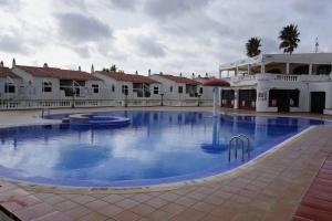 a large swimming pool in front of a building at Apartamento el Descanso in Son Bou