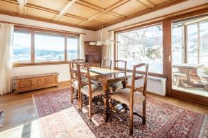 ein Esszimmer mit einem Tisch, Stühlen und Fenstern in der Unterkunft Casa Murissen in Flims