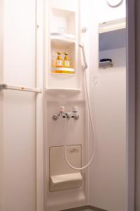 La salle de bains est pourvue d'une douche. dans l'établissement Cozy Vibes Apt Hotel, à Tokyo