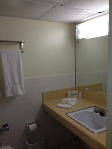 a bathroom with a sink and a mirror at Knights Inn Hallandale in Hollywood