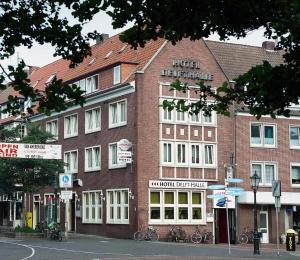 ein großes Backsteingebäude an einer Stadtstraße in der Unterkunft Hotel Delfthalle in Emden