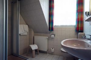 ein Badezimmer mit Waschbecken und Toilette in der Unterkunft Hotel Delfthalle in Emden