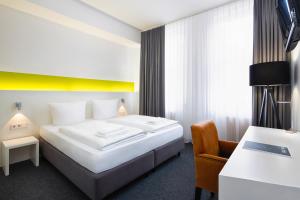 una camera d'albergo con letto e sedia di mk hotel berlin a Berlino