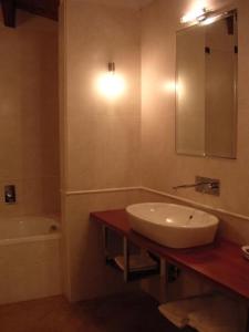 a bathroom with a sink and a tub and a mirror at La Locanda Del Melograno in Moncalvo