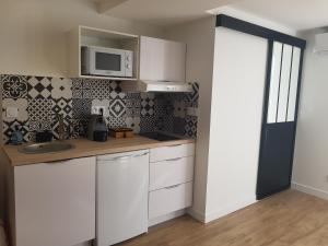 a white kitchen with a sink and a microwave at U STUDIU 7 rue Notre Dame in Bastia +10 photos