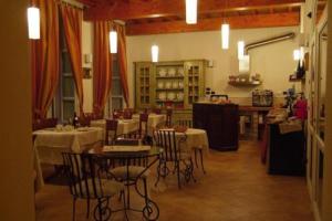 a restaurant with tables and chairs in a room at La Locanda del Melograno in Moncalvo