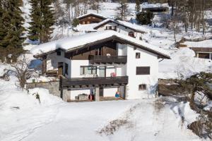 a house with a snow covered roof in the snow at Casa Murissen in Flims