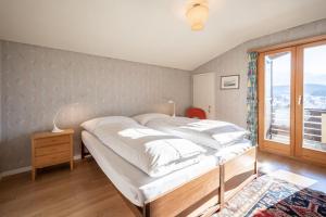 a bedroom with a large bed and a window at Casa Murissen in Flims