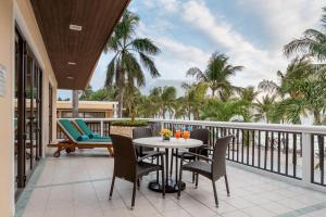 a balcony with a table and chairs and palm trees at Henann Regency Resort and Spa in Boracay