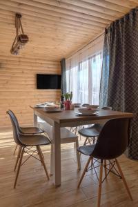 a dining room with a table and chairs and a television at Istebna Pełna chata in Istebna