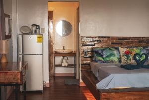 een kamer met een bed, een koelkast en een wastafel bij YAMA APARTMENTS - Private Beachfront in General Luna