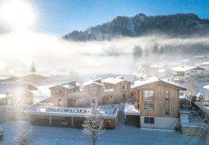 Eine Stadt im Schnee mit Nebel im Hintergrund in der Unterkunft Alpegg Chalets in Waidring