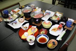 a table topped with plates of food and bowls of soup at Hotel Grand Toya in Lake Toya