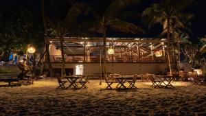 a group of tables and chairs on the beach at night at Banana Fan Sea Resort in Chaweng