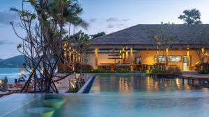 a villa with a swimming pool in front of a house at Banana Fan Sea Resort in Chaweng