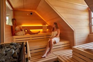 Due donne sedute in una sauna di Das Landhotel Weingut Gernert a Sankt Martin