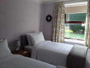 a hotel room with two beds and a window at The Annexe Cottage at Newhouse Farm in Lanark
