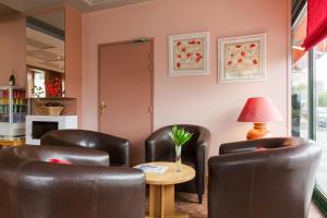 a waiting room with leather chairs and a table at The Originals Boutique, Hôtel Alizé, Évian-les-Bains (Inter-Hotel) in Évian-les-Bains