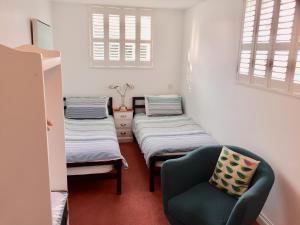 a bed room with two beds and a desk at Derrin Guest House in Larne