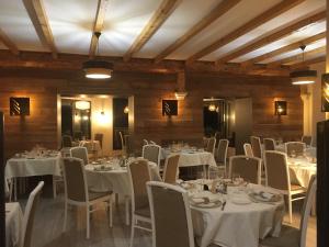 a dining room with white tables and chairs at Logis Hotel Restaurant des Sapins in Lanarce