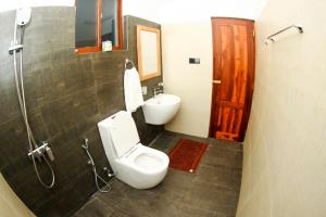 a bathroom with a toilet and a sink at Bay Hiriketiya in Hiriketiya