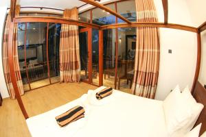 a bedroom with a bed and a large window at Bay Hiriketiya in Hiriketiya