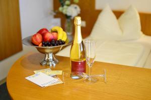 a bottle of champagne and a bowl of fruit on a table at Erlebnishotel Kärnten-Mölltal 3 Stern Superior in Obervellach