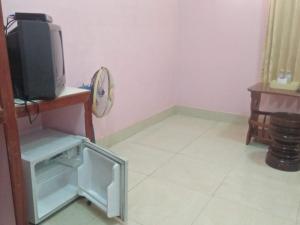Zimmer mit einem TV und einem kleinen Kühlschrank. in der Unterkunft Sam So Guesthouse in Siem Reap + 17 Fotos