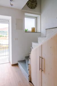 eine Treppe in einem Haus mit einer Uhr an der Wand in der Unterkunft Apartmani Moon in Trebinje