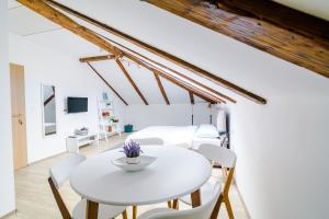 a white dining room with a white table and chairs at Apartmani Moon in Trebinje