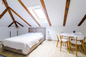 a bedroom with a bed and a table and chairs at Apartmani Moon in Trebinje