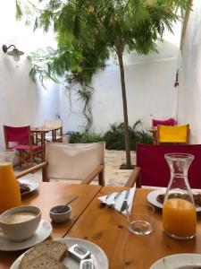 a wooden table with food and orange juice on it at HoMe Hotel Menorca in Ciutadella