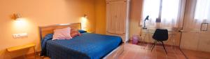 a bedroom with a bed and a chair in it at Torre del Prior in Tortosa