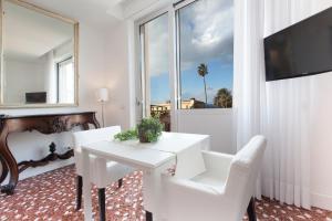 a white dining room with a white table and chairs at Sorrento Apartments in Sorrento