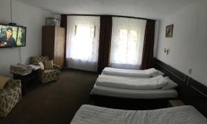 Habitación de hotel con 3 camas y TV. en Iony Apartament, en Sibiu