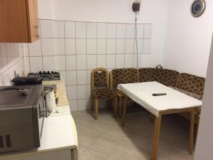 Una cocina con una mesa y sillas en una cocina. en Iony Apartament, en Sibiu