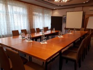 a conference room with tables and chairs and a screen at Brauereigasthof Dachsenfranz in Zuzenhausen