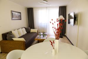 a living room with a white table and a couch at Ferienwohnung Mahlsdorf-Ein Quäntchen mehr in Berlin