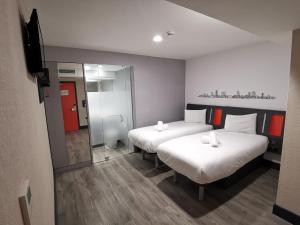 a hotel room with two beds and a mirror at easyHotel Leeds in Leeds +46 photos