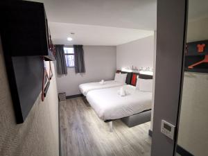 Un pat sau paturi într-o cameră la easyHotel Leeds